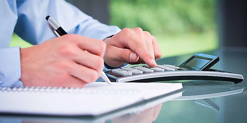 Jahresabschluss und Finanzberechnung mit Taschenrechner und Notizen